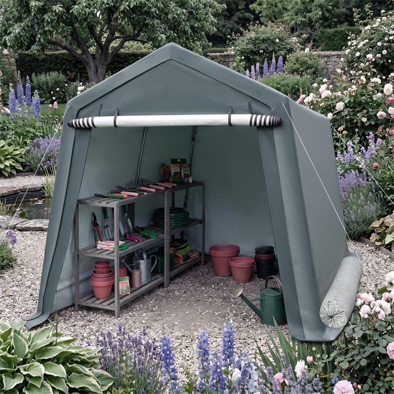 A large outdoor garden shed tent in a muted sage green color, set up in a landscaped garden with gravel flooring and gardening tools stored inside.